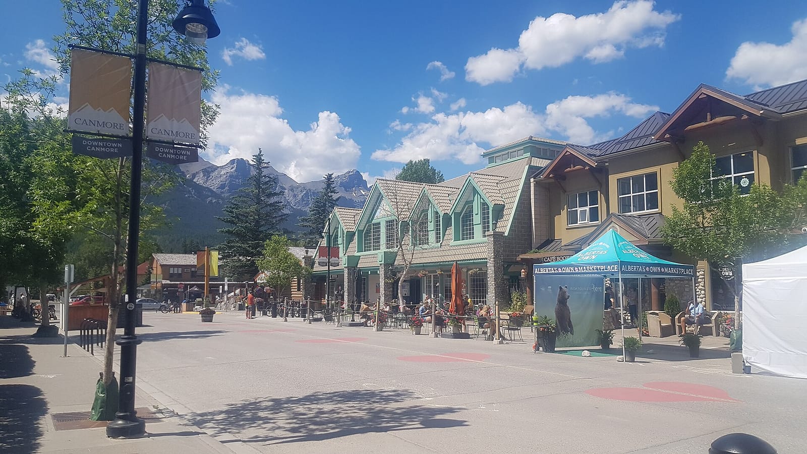 Canmore's main street, pedestrian-only in summer, with patios and mountains behind