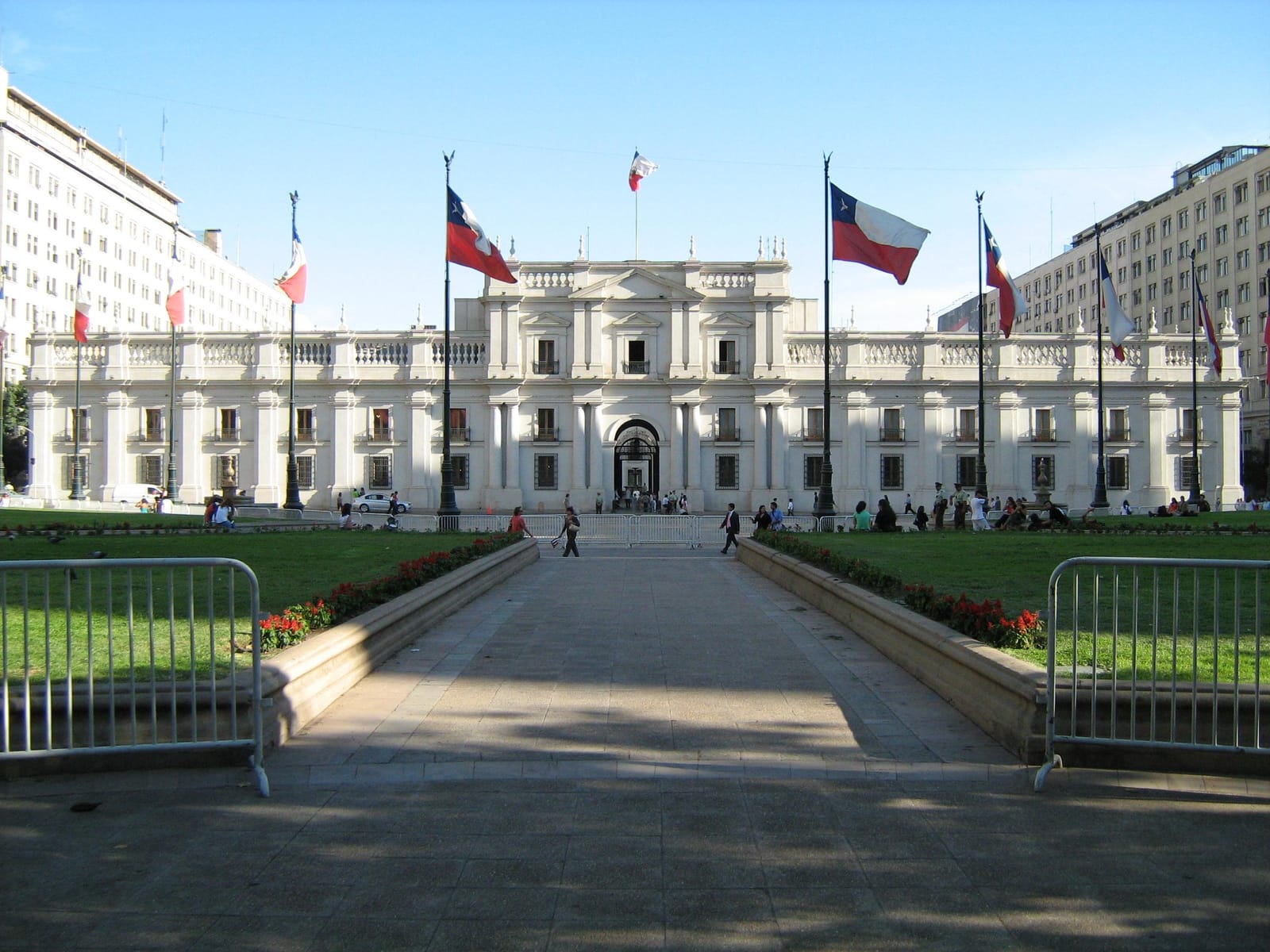 White facade of the Palacio de La Moneda with Chilean flags